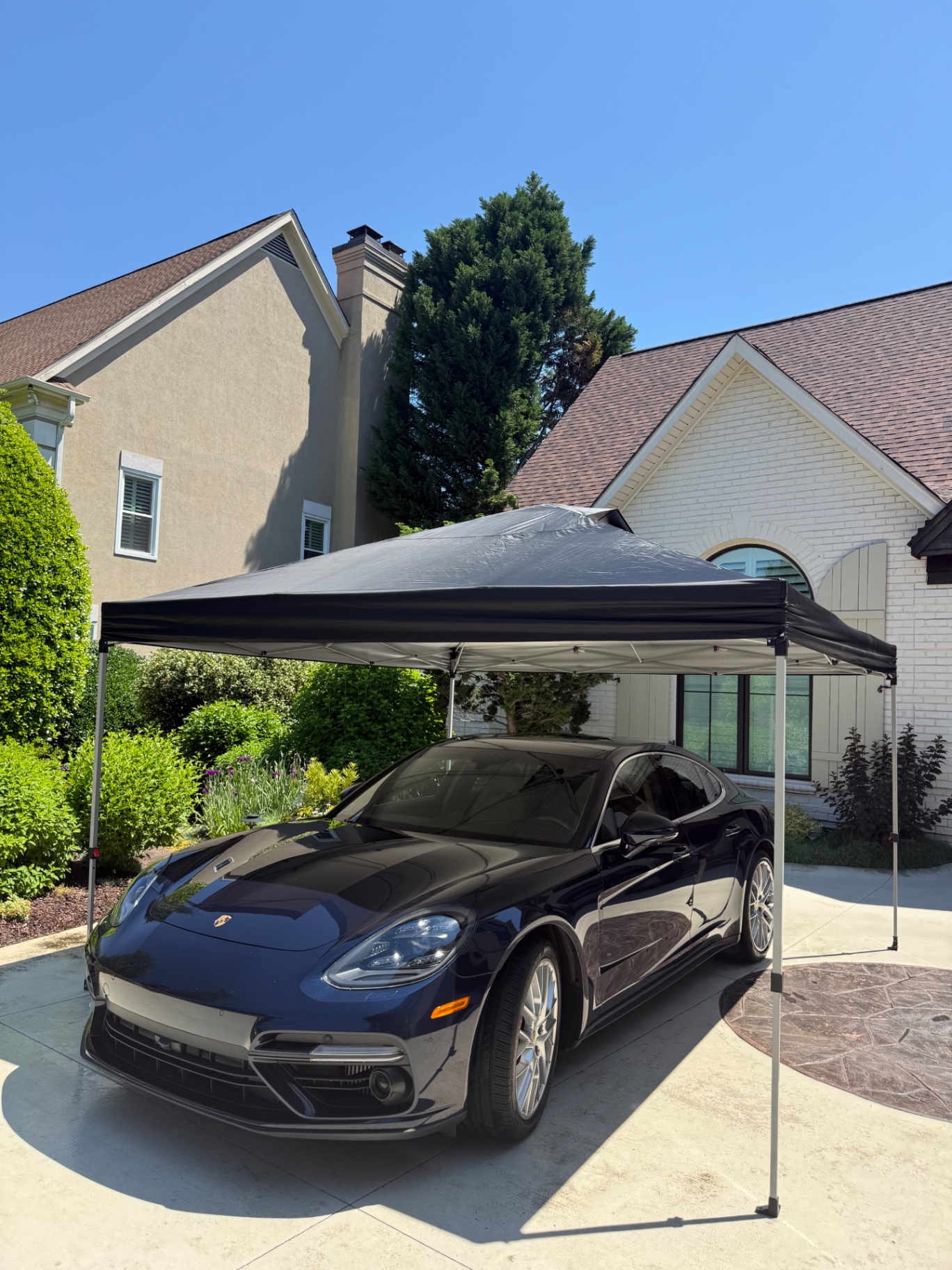 Dark Porsche Panamera under shade canopy before or during exterior service